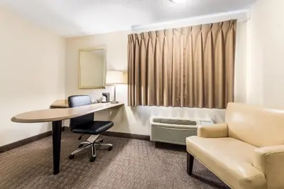 a hotel room with a bed and a desk and a chair at Red Roof Inn Cleveland Airport - Middleburg Heights in Middleburg Heights