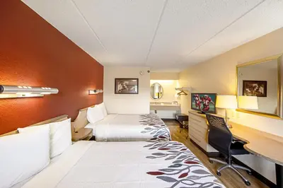 a hotel room with two beds and a desk at Red Roof Inn Toledo University in Toledo