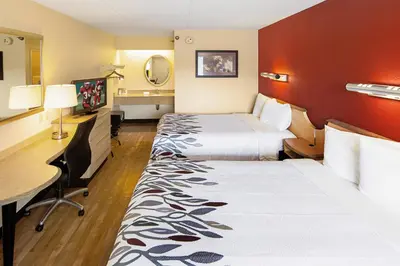 a hotel room with two beds and a desk at Red Roof Inn Toledo University in Toledo
