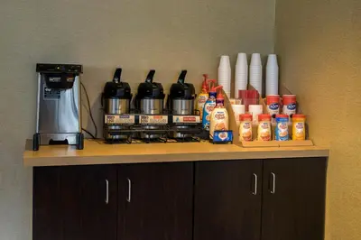 a counter top with a coffee maker and condiments at Red Roof Inn Toledo University in Toledo