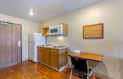 a small kitchen with a table and a refrigerator at Extended Stay America Select Suites - Cleveland - Mentor in Mentor
