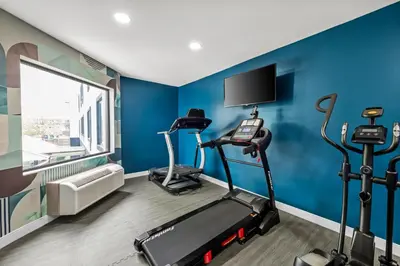 a room with a gym with blue walls at MainStay Suites Columbus North - Worthington in Columbus