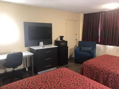 a hotel room with a bed and a tv and a chair at Days Inn by Wyndham Grove City Columbus South in Grove City
