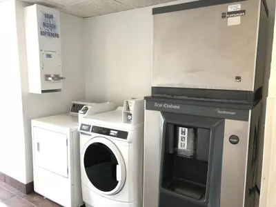 a laundry room with a washing machine and a washer at Days Inn by Wyndham Grove City Columbus South in Grove City