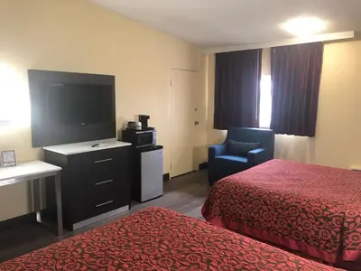 a hotel room with two beds and a flat screen tv at Days Inn by Wyndham Grove City Columbus South in Grove City