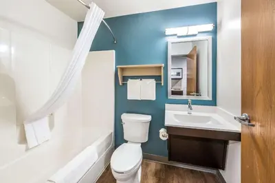 a bathroom with a white toilet and a sink at WoodSpring Suites Columbus West - Hilliard in Hilliard