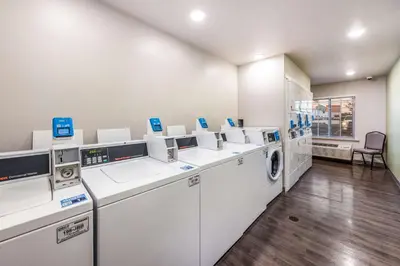 a laundry room with white washers and dryers at WoodSpring Suites Columbus West - Hilliard in Hilliard