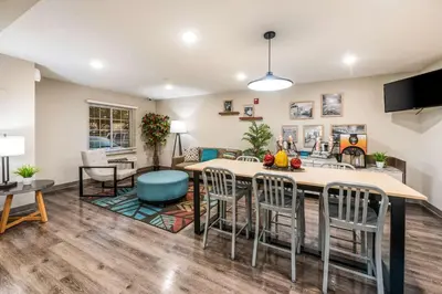 a living room and dining room with a table and chairs at WoodSpring Suites Columbus West - Hilliard in Hilliard
