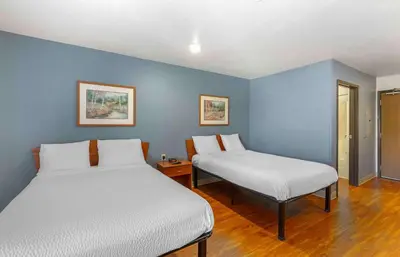 two beds in a room with blue walls at Extended Stay America Select Suites - Akron - South in Portage Lakes