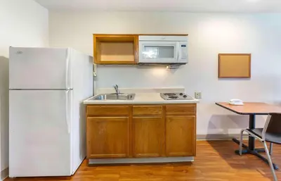 a kitchen with a white refrigerator and a sink at Extended Stay America Select Suites - Akron - South in Portage Lakes
