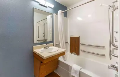 a bathroom with a sink and a bath tub with a mirror at Extended Stay America Select Suites - Akron - South in Portage Lakes