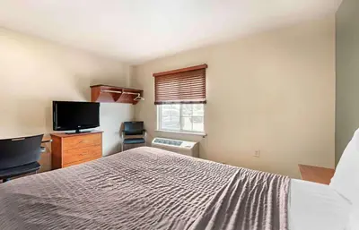 a bedroom with a bed and a flat screen tv at Extended Stay America Select Suites - Cincinnati - Florence - Airport in Florence