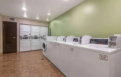 a laundry room with washers and dryers in a building at Extended Stay America Select Suites - Cincinnati - Florence - Airport in Florence