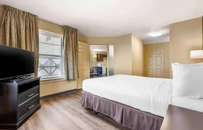 a hotel room with a bed and a flat screen tv at Extended Stay America Suites - Columbus - Polaris in Columbus