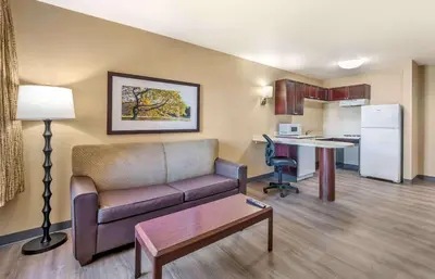 a living room with a couch and a table and a kitchen at Extended Stay America Suites - Columbus - Polaris in Columbus