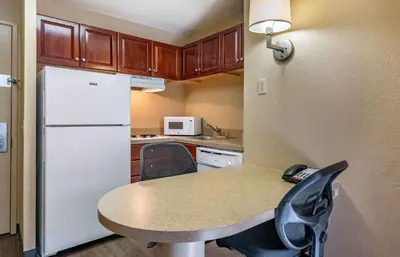 a kitchen with a table and a white refrigerator at Extended Stay America Suites - Columbus - Polaris in Columbus