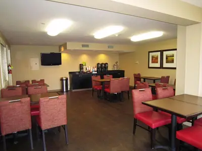 a dining room with tables and chairs and a television at Extended Stay America Suites - Columbus - Polaris in Columbus