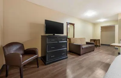 a living room with a flat screen tv and chairs at Extended Stay America Suites - Toledo - Holland in Holland
