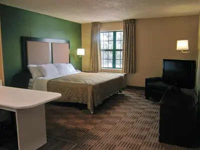 a hotel room with a bed and a television at Extended Stay America Suites - Toledo - Holland in Holland