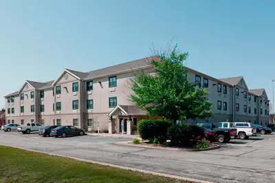 a large building with cars parked in a parking lot at Extended Stay America Suites - Toledo - Holland in Holland