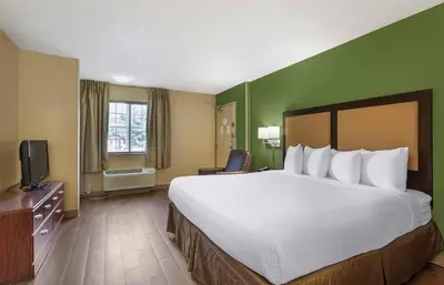 a hotel room with a large bed and a television at Extended Stay America Suites - Cincinnati - Springdale - I-275 in Springdale