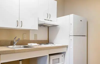 a kitchen with white cabinets and a white refrigerator at Extended Stay America Suites - Cincinnati - Springdale - I-275 in Springdale