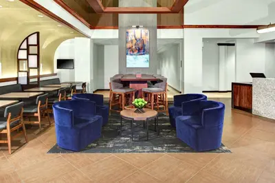 a hotel lobby with blue chairs and a table at Hyatt Place Cincinnati Airport in Florence