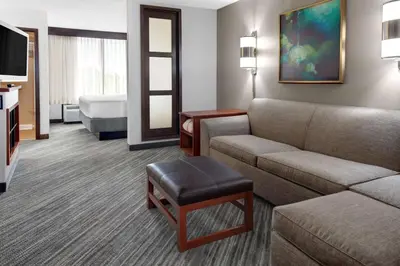 a hotel room with a couch and a bed at Hyatt Place Cincinnati Airport in Florence