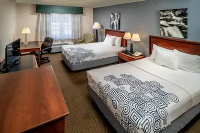 a hotel room with two beds and a desk at Rodeway Inn in Barboursville