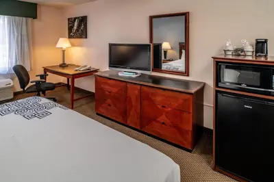a hotel room with a bed and a flat screen tv at Rodeway Inn in Barboursville