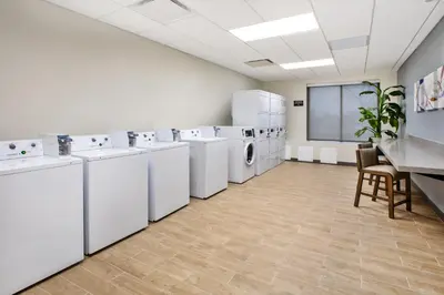 a laundry room with white washing machines and a chalkboard at Candlewood Suites - Cincinnati Northeast - Mason by IHG in Mason
