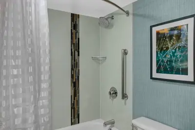 a bathroom with a shower and a white toilet at Candlewood Suites - Cincinnati Northeast - Mason by IHG in Mason
