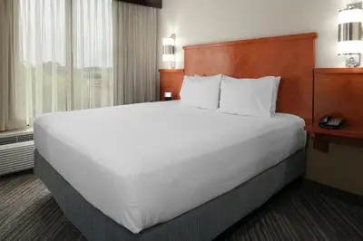 a large white bed in a hotel room at Candlewood Suites - Cincinnati Northeast - Mason by IHG in Mason