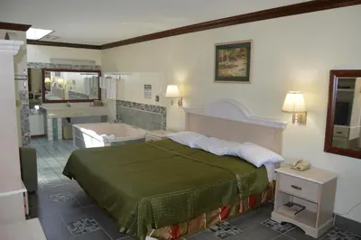 a bedroom with a bed and a bath tub at Economy Inn Cuyahoga Falls in Cuyahoga Falls
