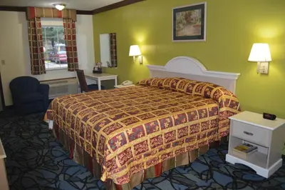 a hotel room with a bed and a chair at Economy Inn Cuyahoga Falls in Cuyahoga Falls