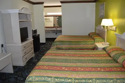 a hotel room with two beds and a television at Economy Inn Cuyahoga Falls in Cuyahoga Falls