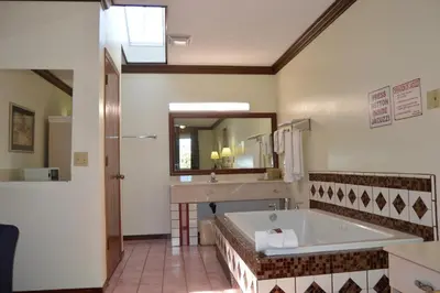 a bathroom with a tub and a sink and a mirror at Economy Inn Cuyahoga Falls in Cuyahoga Falls