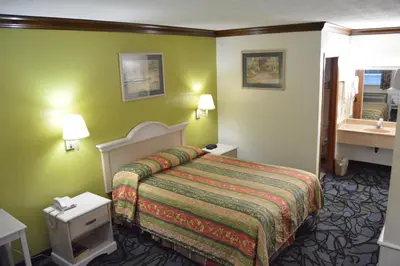 a hotel room with a bed and a bathroom at Economy Inn Cuyahoga Falls in Cuyahoga Falls
