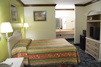 a hotel room with a bed and a bathroom at Economy Inn Cuyahoga Falls in Cuyahoga Falls