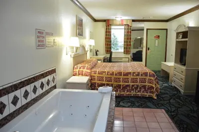 a hotel room with a bed and a bath tub at Economy Inn Cuyahoga Falls in Cuyahoga Falls