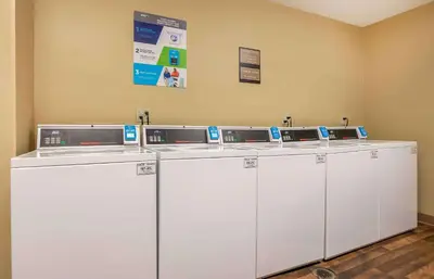 a row of white washing machines in a room at Extended Stay America Suites - Cincinnati - Blue Ash - Kenwood Road in Blue Ash