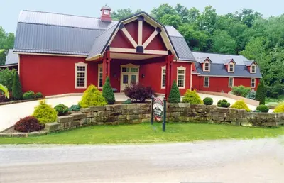 a red house with a sign in front of it at The Barn Inn Bed and Breakfast in Millersburg