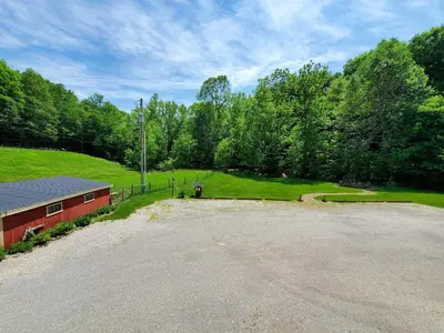 an empty parking lot next to a red building at The Barn Inn Bed and Breakfast in Millersburg