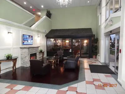 a lobby with chairs and a fireplace in a building at Days Inn by Wyndham Columbus East Airport in Columbus