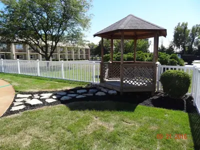 a gazebo in a yard with a white fence at Days Inn by Wyndham Columbus East Airport in Columbus