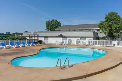 a large swimming pool with chairs and a gazebo at Days Inn by Wyndham Columbus East Airport in Columbus