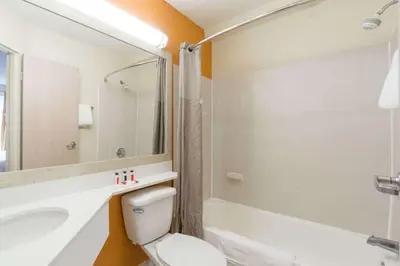 a bathroom with a toilet and a sink and a tub at Days Inn by Wyndham Florence Cincinnati Area in Florence