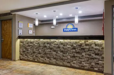 a day inn sign on a wall in a lobby at Days Inn by Wyndham Florence Cincinnati Area in Florence