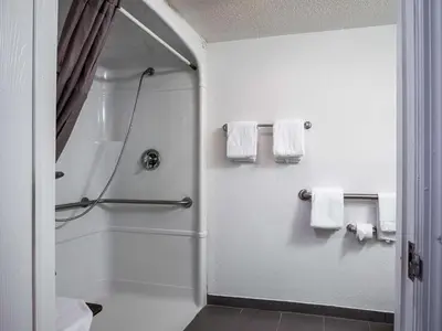 a bathroom with a shower and white towels at Studio 6-Miamisburg, OH - Dayton in Miamisburg