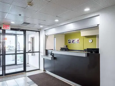an office with a reception desk and a exit sign at Studio 6-Miamisburg, OH - Dayton in Miamisburg